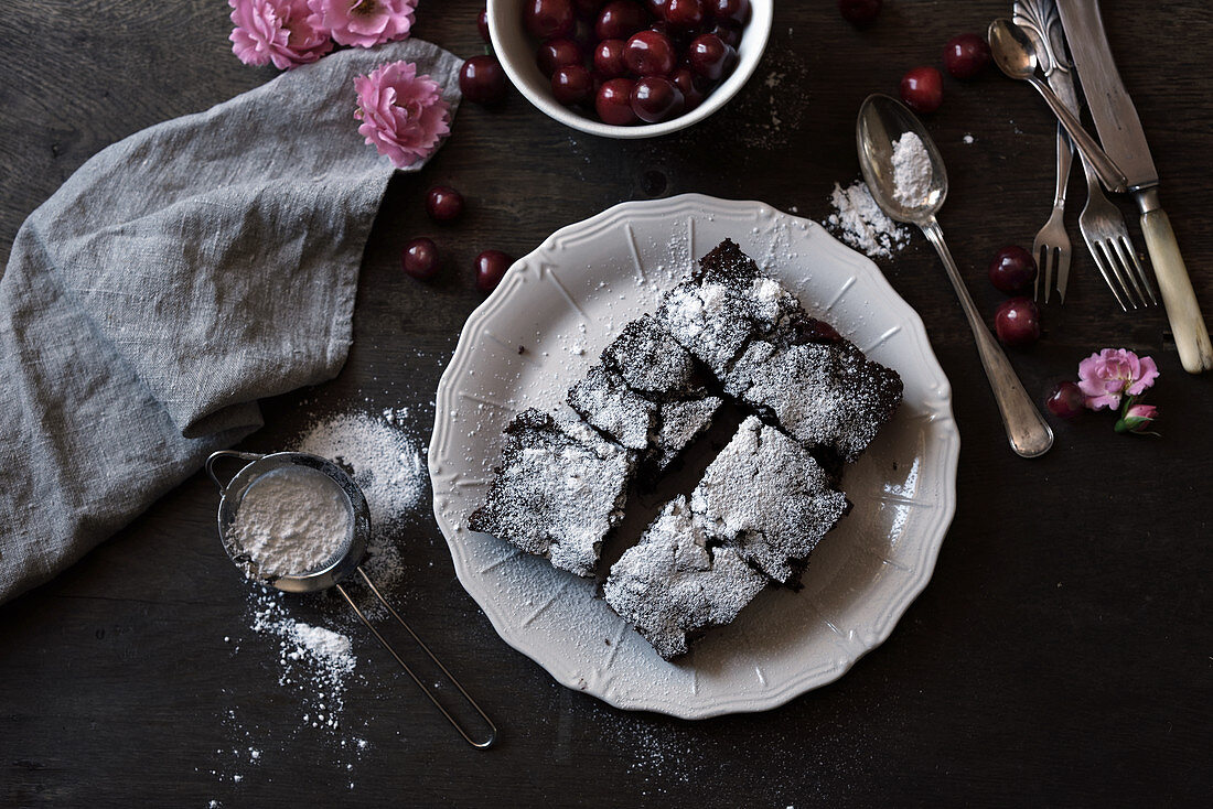 Schokoladenkuchen mit Kirschen und Puderzucker