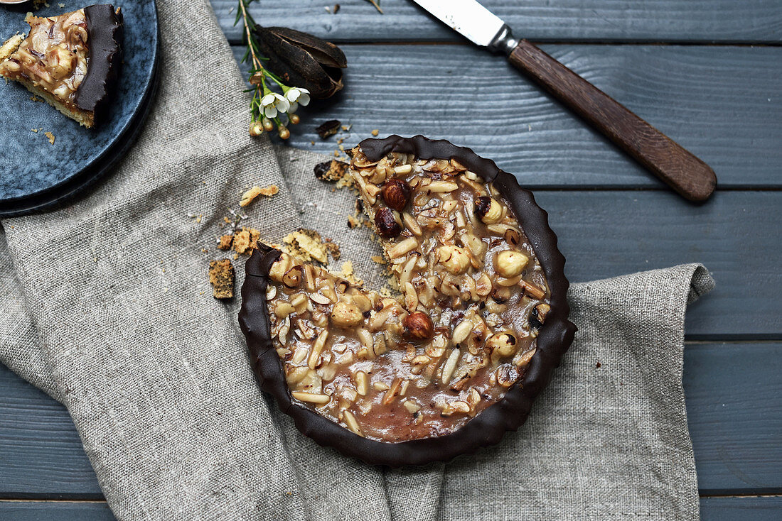 Nut cake with a chocolate edge on a rustic wooden table