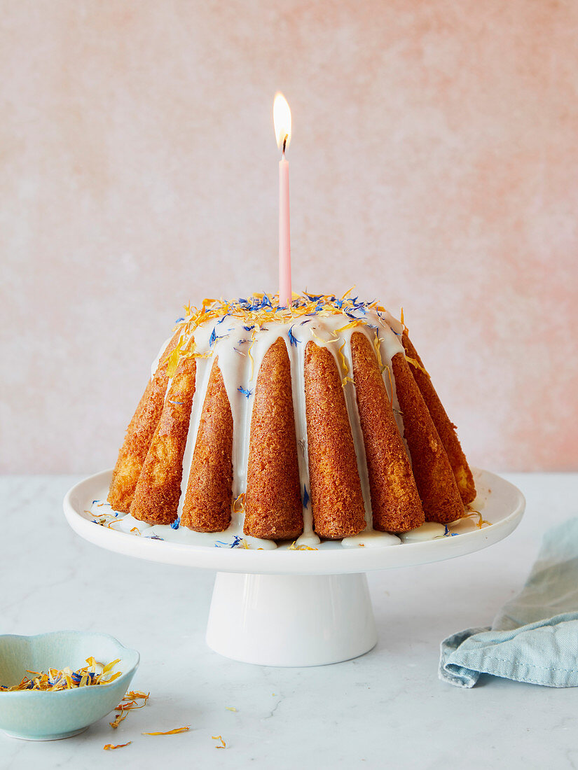 Lemon Drizzle Cake als Geburtstagskuchen mit Kerze und Zuckerglasur