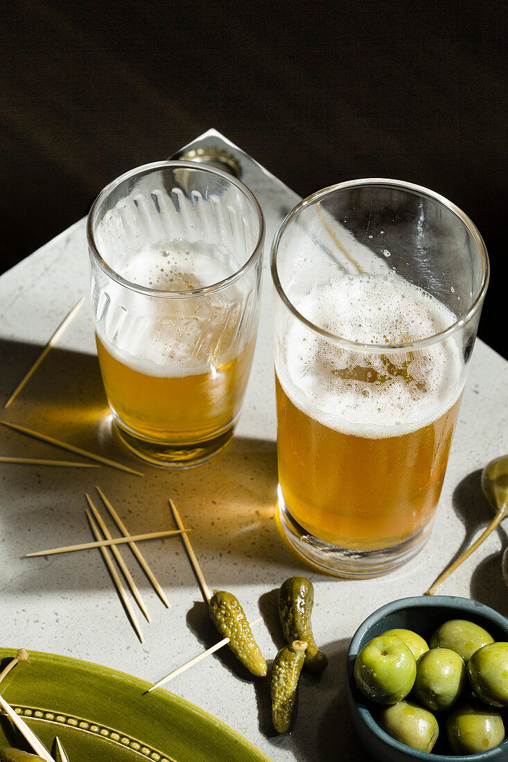 Beer and snacks: a selection of pickled gherkins, caper berries and green olives