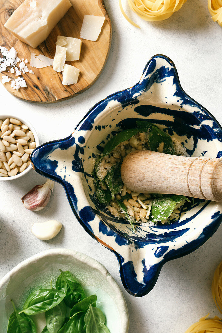 Pestle and mortar with ingredients for pesto sauce