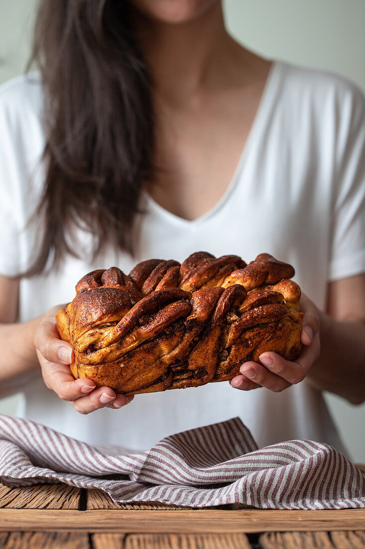 Frau hält Zimt-Babka in den Händen