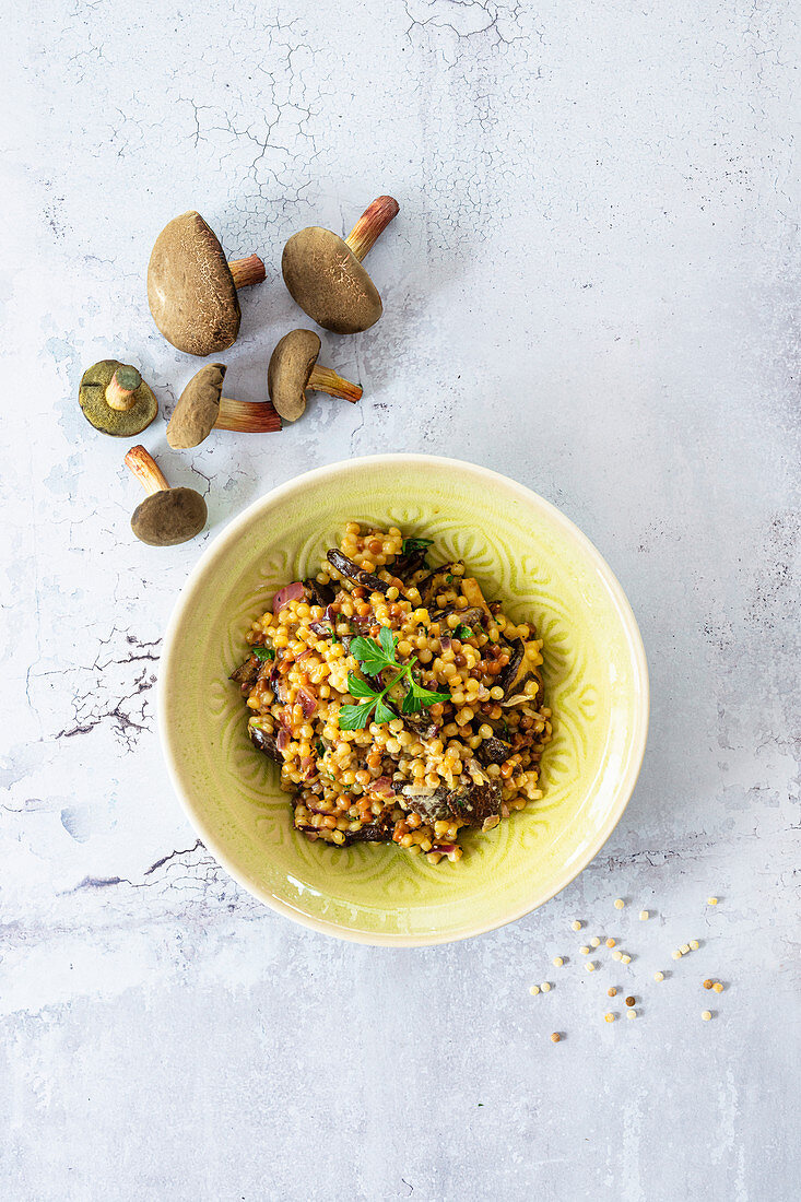 Fregola (Knopfnudeln, Sardinien) mit Waldpilzen und roten Zwiebeln