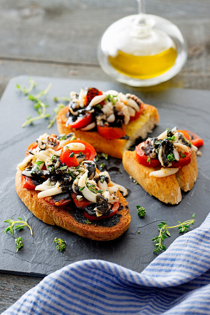 Sepia-Crostini mit Kirschtomaten und Tintenfisch