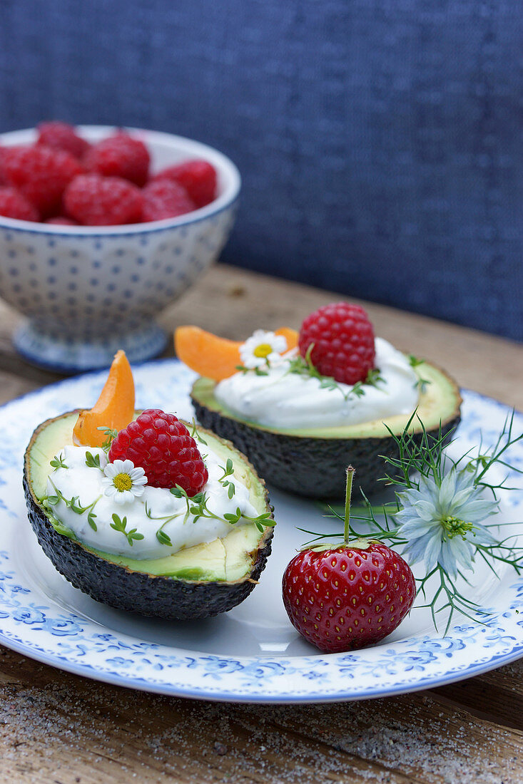 An avocado filled with herb cream and fruit