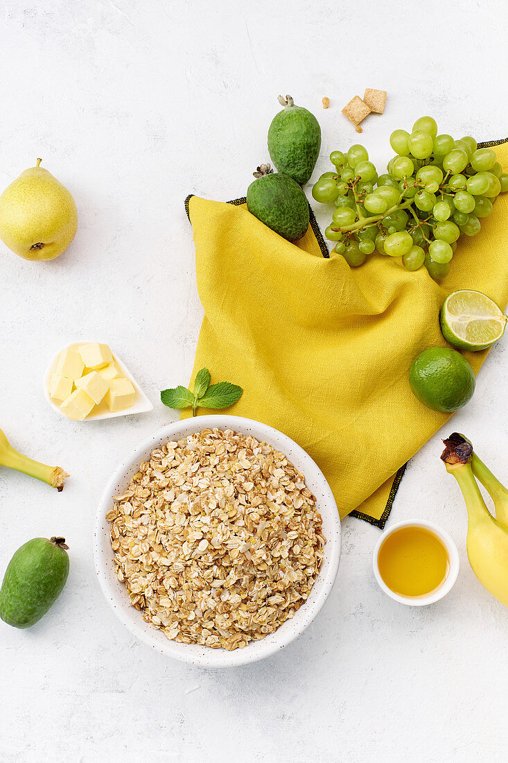 Zutaten für gesundes Frühstück: Haferflocken, Trauben, Guave, Limetten, Bananen und Birnen