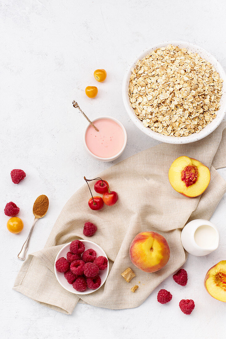 Zutaten für gesundes Frühstück: Haferflocken, Himbeeren und Pfirsiche