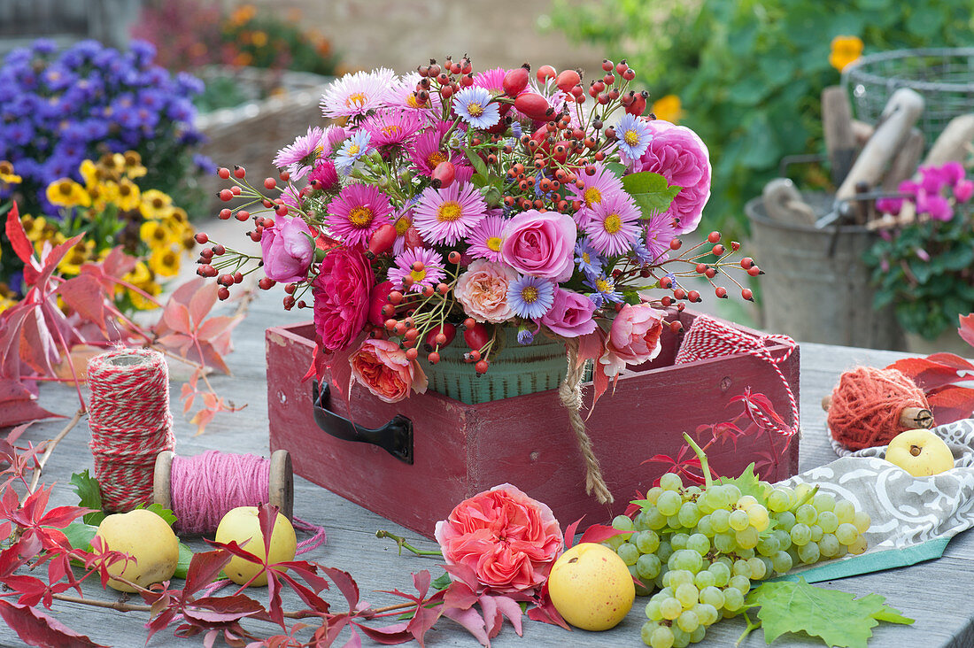 Autumn bouquet of asters, roses and rose hips, tendrils of five-leaved ivy