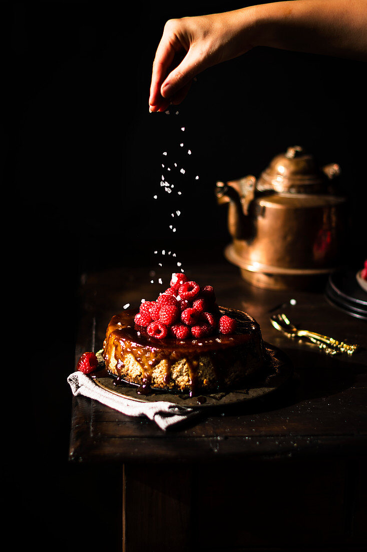 Vegan cheesecake with salted caramel sauce and raspberries