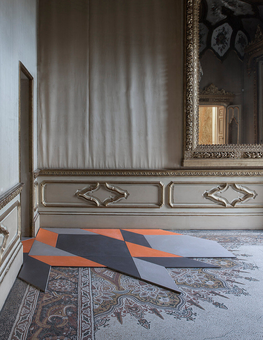 Modern, geometric tiles on antique mosaic floor