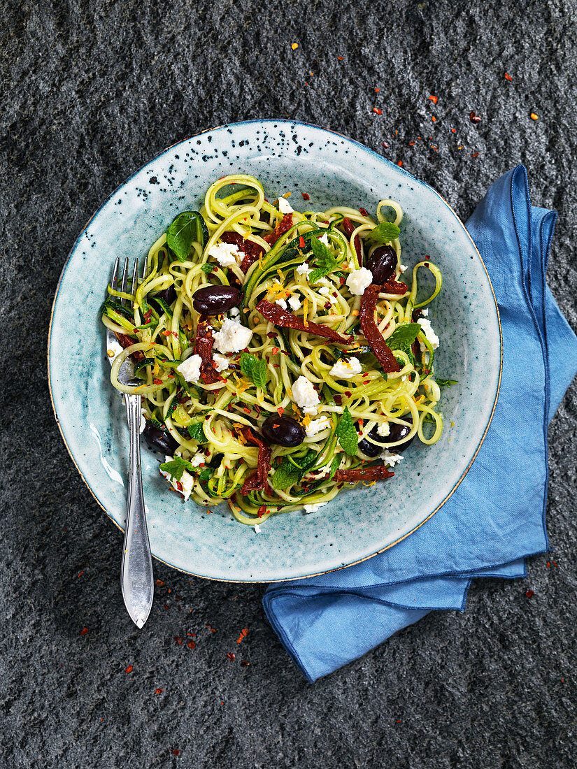 Zucchininudeln mit getrockneten Tomaten, Oliven und Feta