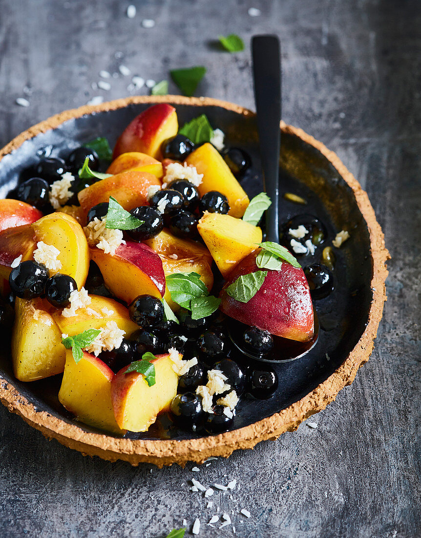 Steamed peach with blueberries and coconut flakes