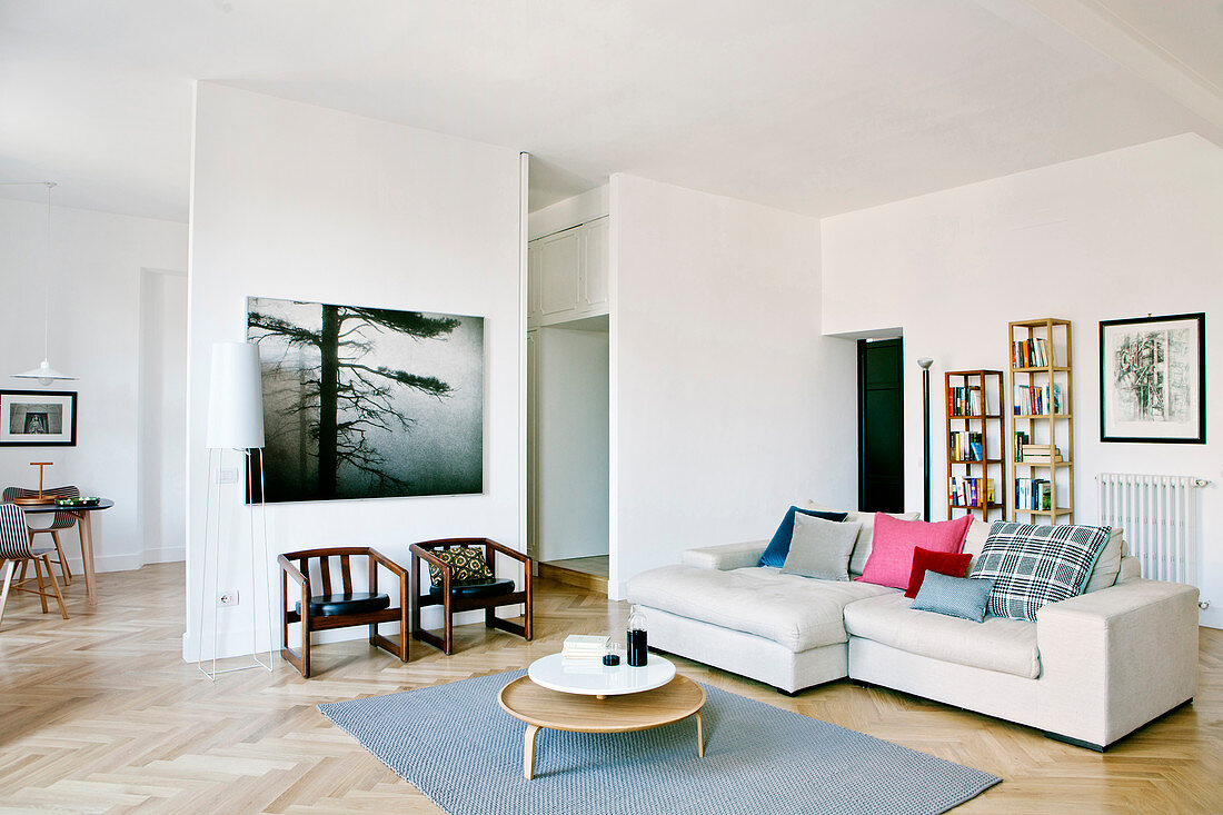Pale sofa in modern open-plan interior with herringbone parquet floor