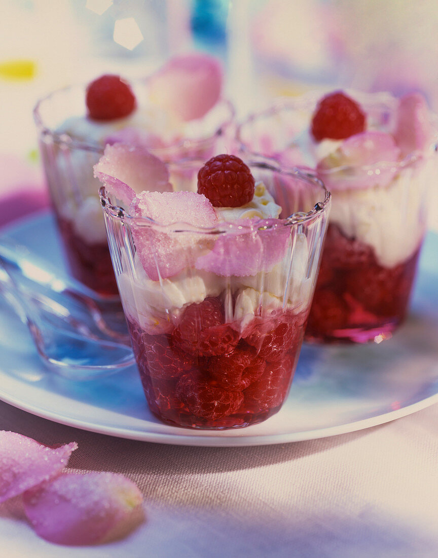 A summer dessert with raspberries, cream and sugared rose petals