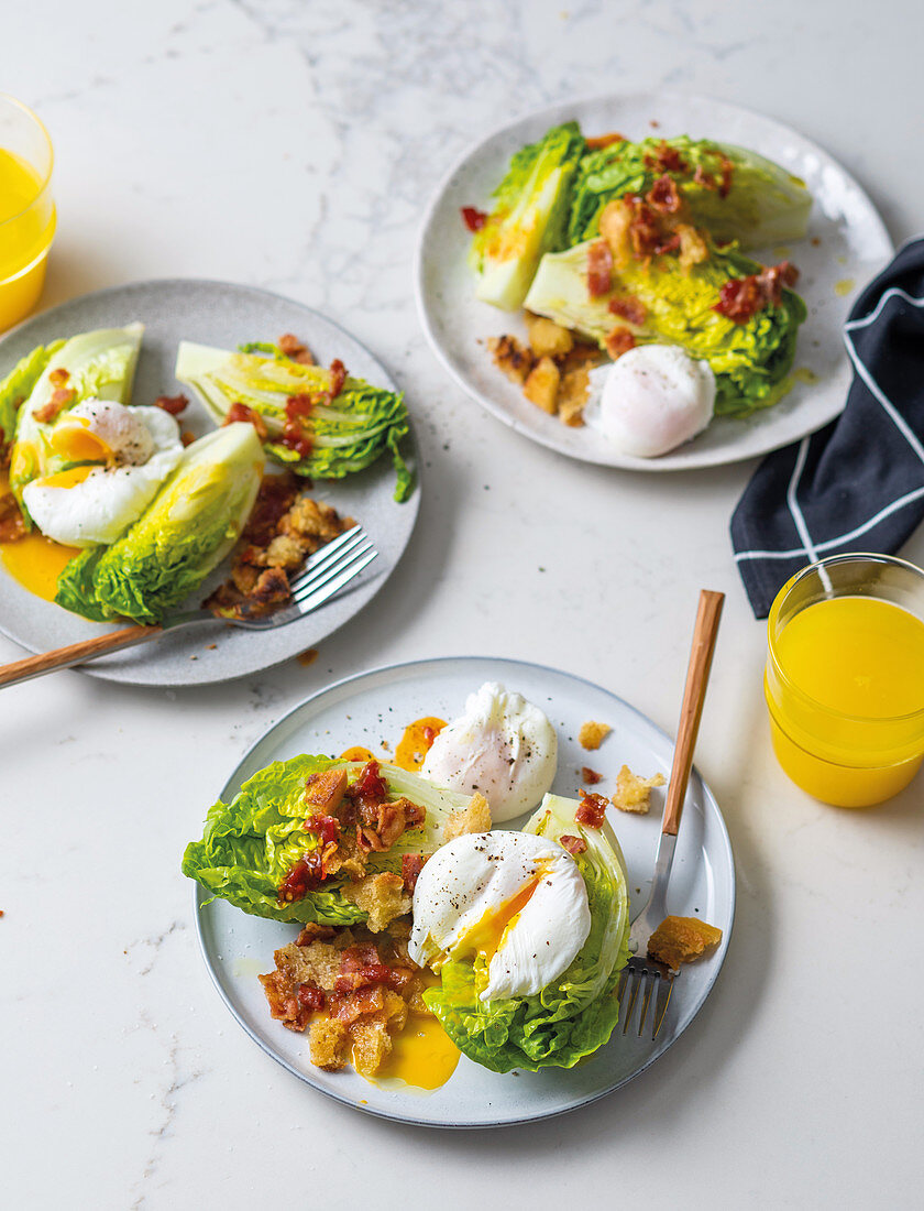 Breakfast salad with poached eggs and bacon croutons