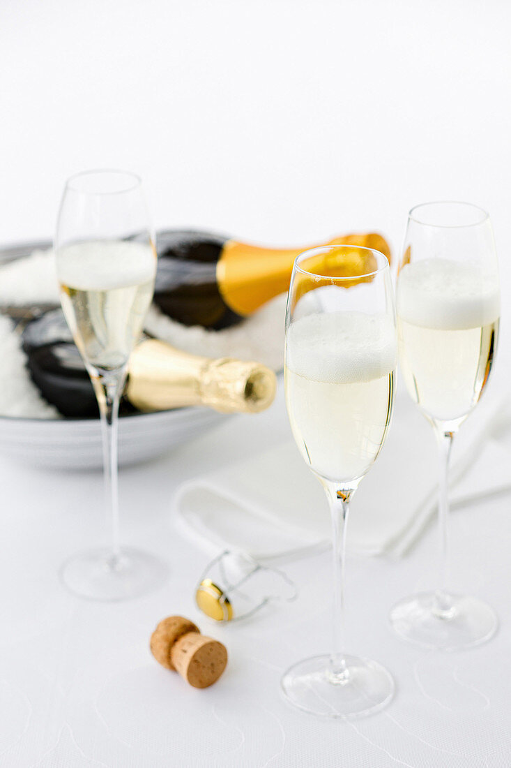 Champagnerflaschen in Eis und Champagner im Glas
