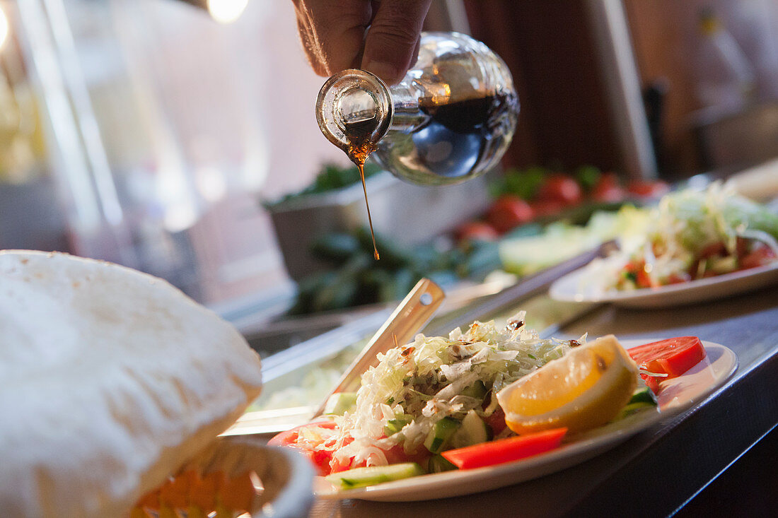 Essig über Salat giessen