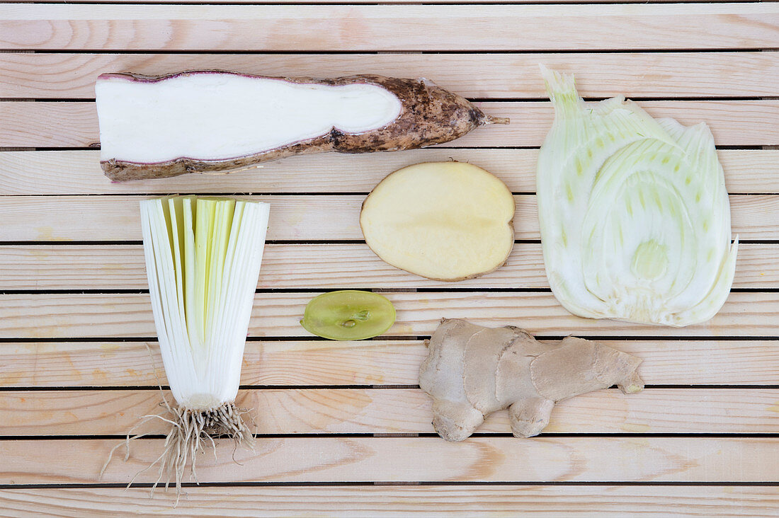 Flatlay of nutritious white fruits and vegetables arranged on a wooden background