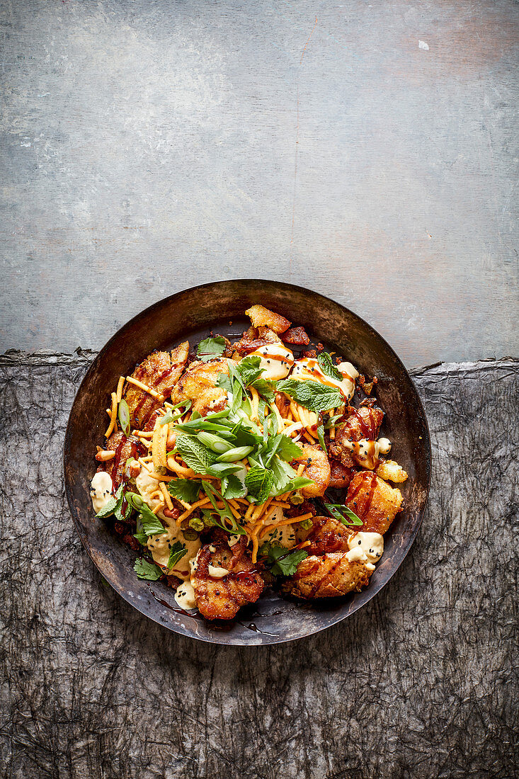 Crushed fried potatoes with curry powder salt, lime pickle yogurt and bombay mix