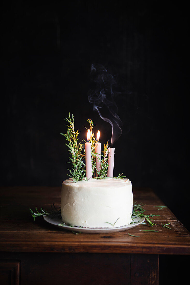 Lebkuchen-Schichttorte dekoriert mit Rosmarin und Kerzen