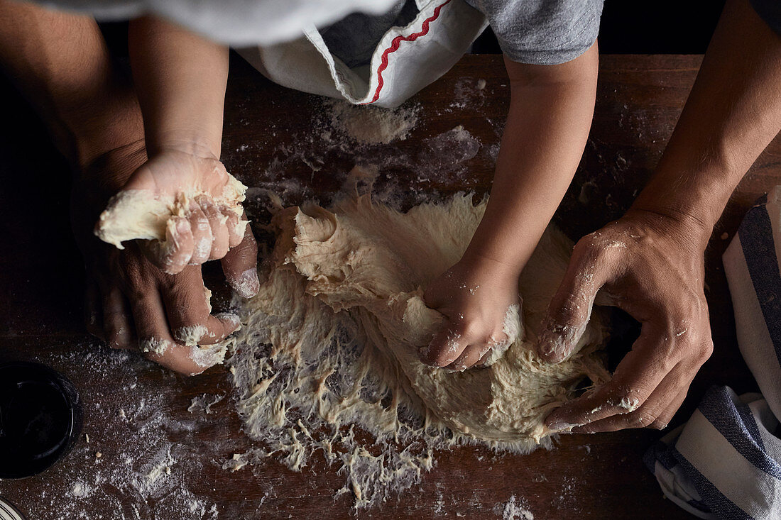 Father and daughter kneading the dough together