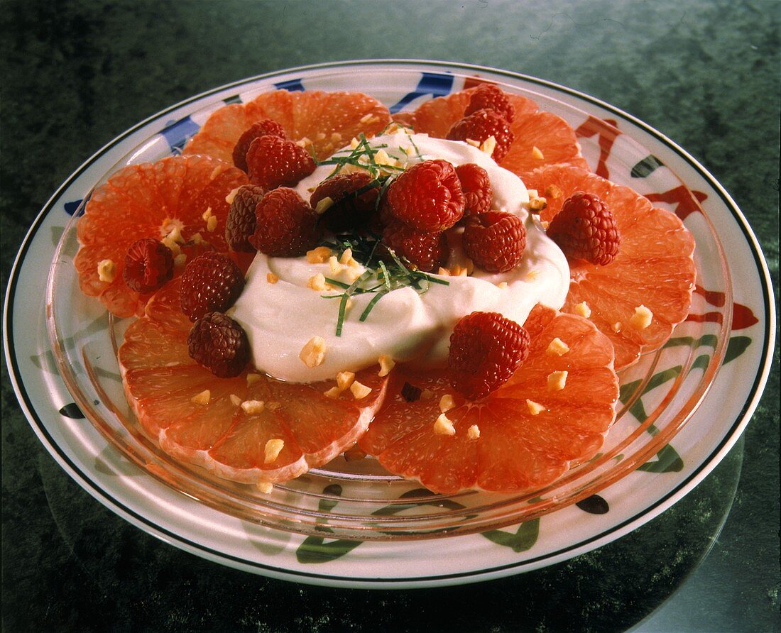 Grapfruitscheiben mit Joghurt, Himbeeren & gehackten Nüssen