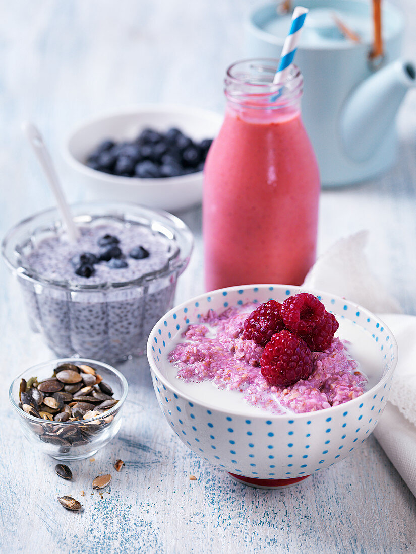 Healthy breakfast with chiapudding with blueberries, smoothie, porridge with raspberries, pumpkinseeds