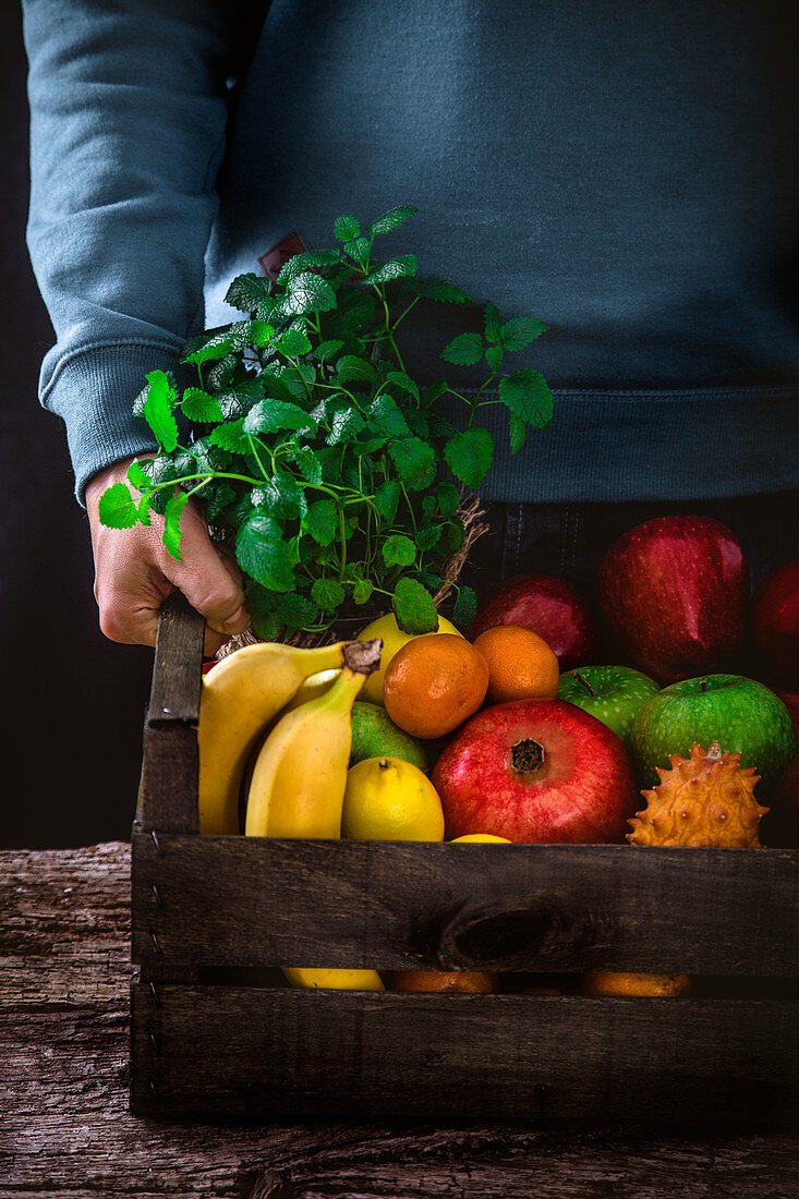 Farmer holding harvested fruit and vegetables