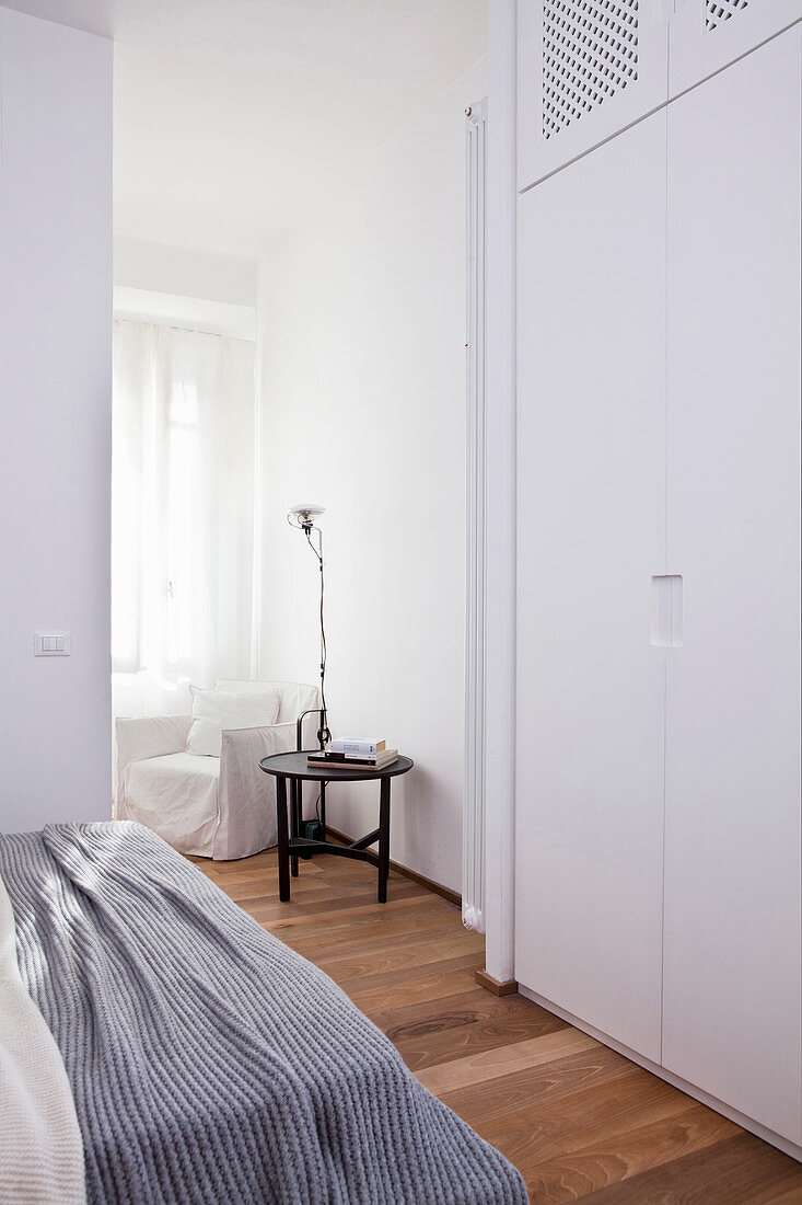 Blick vom Schlafzimmer mit deckenhohem Kleiderschrank auf Sitzecke am Fenster