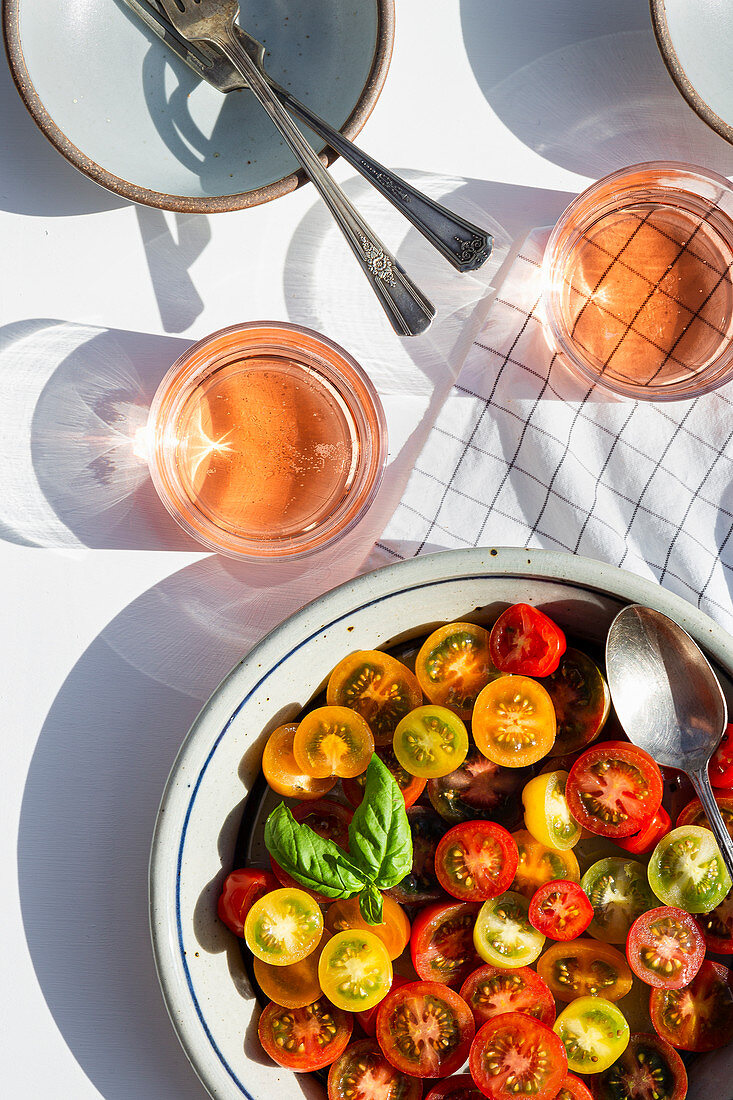 Tomatensalat aus bunten Kirschtomaten serviert mit Getränk