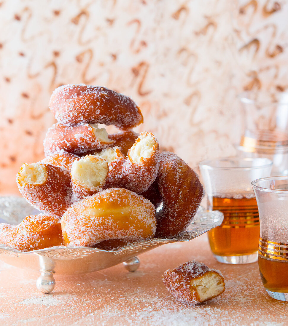 Sugared donuts served with glasses of tea