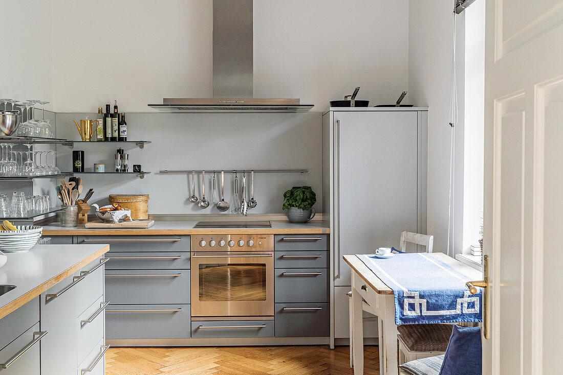 Pale grey fitted kitchen with island counter