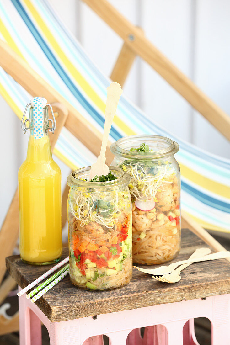 Glass noodle salad with vegetables and sprouts in glass jars for a picnic
