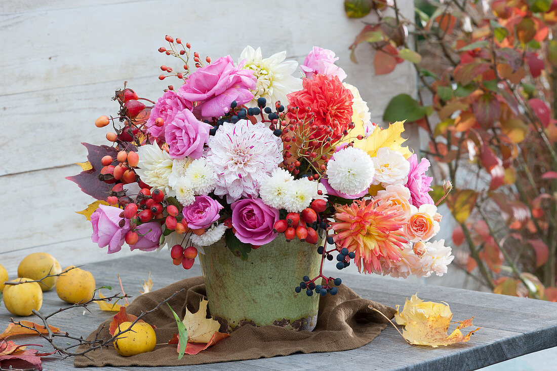 Autumn bouquet with dahlias, roses, chrysanthemums, rose hips, ornamental apples, and five-leaved ivy berries