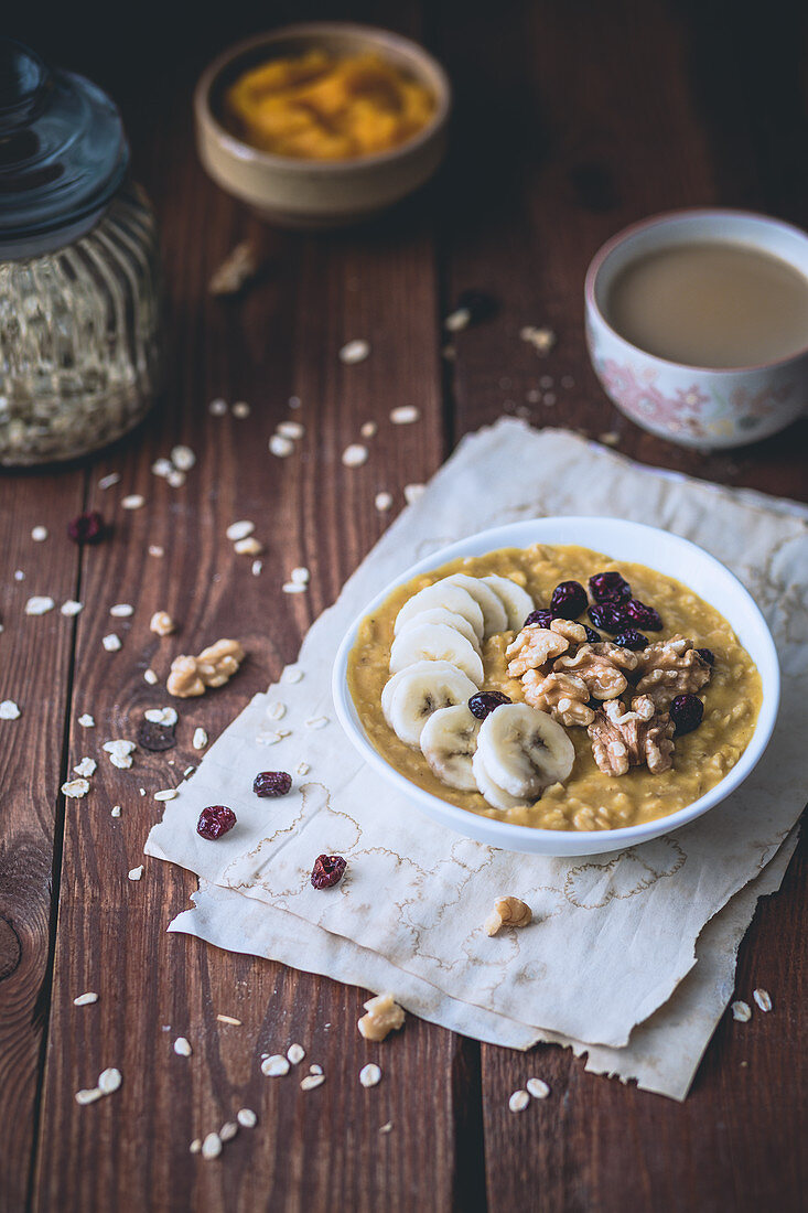 Kürbis-Porridge mit Banane, getrockneten Cranberries und Walnüssen