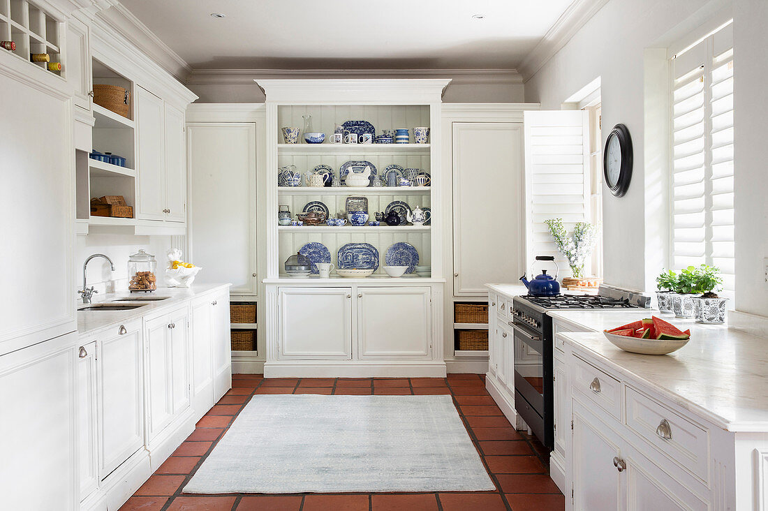 White, country-house-style kitchen with collection of blue-and-white crockery on dresser
