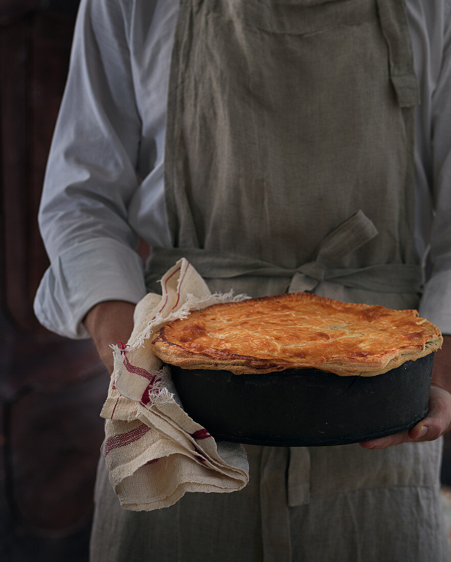 Man holding homebaked pie with crust