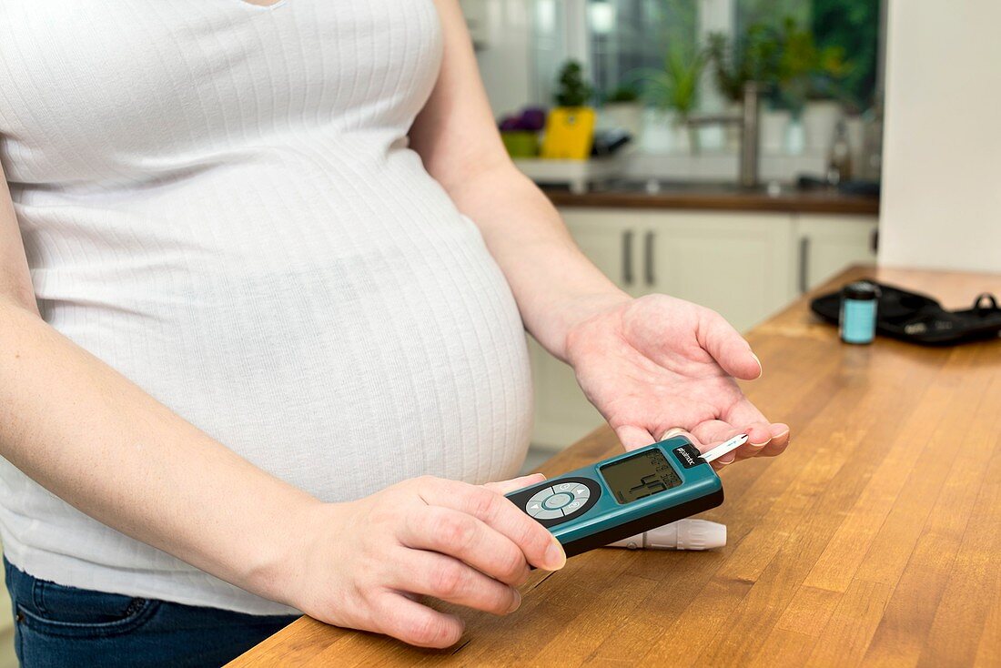 Pregnant woman testing blood sugar level in diabetes