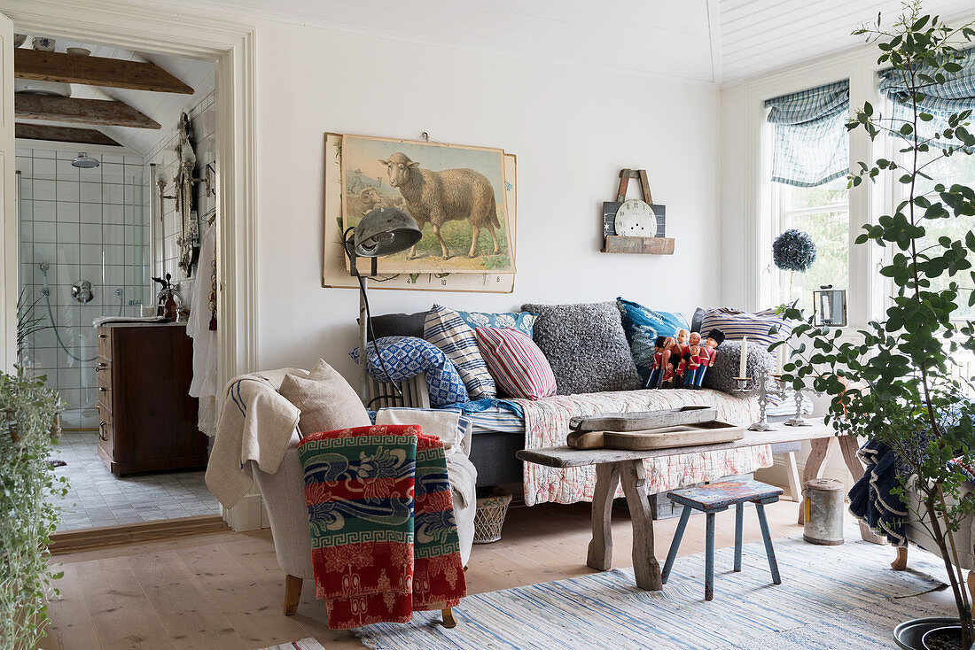 Cosy, country-house-style living room with view into bathroom