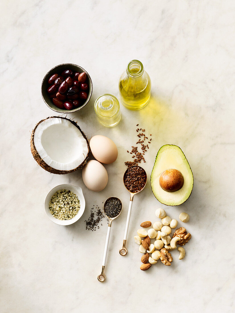 Auswahl gesunder Fette: Ei, Samen, Kokosnuss, Speiseöl, Nüsse und Bohnen