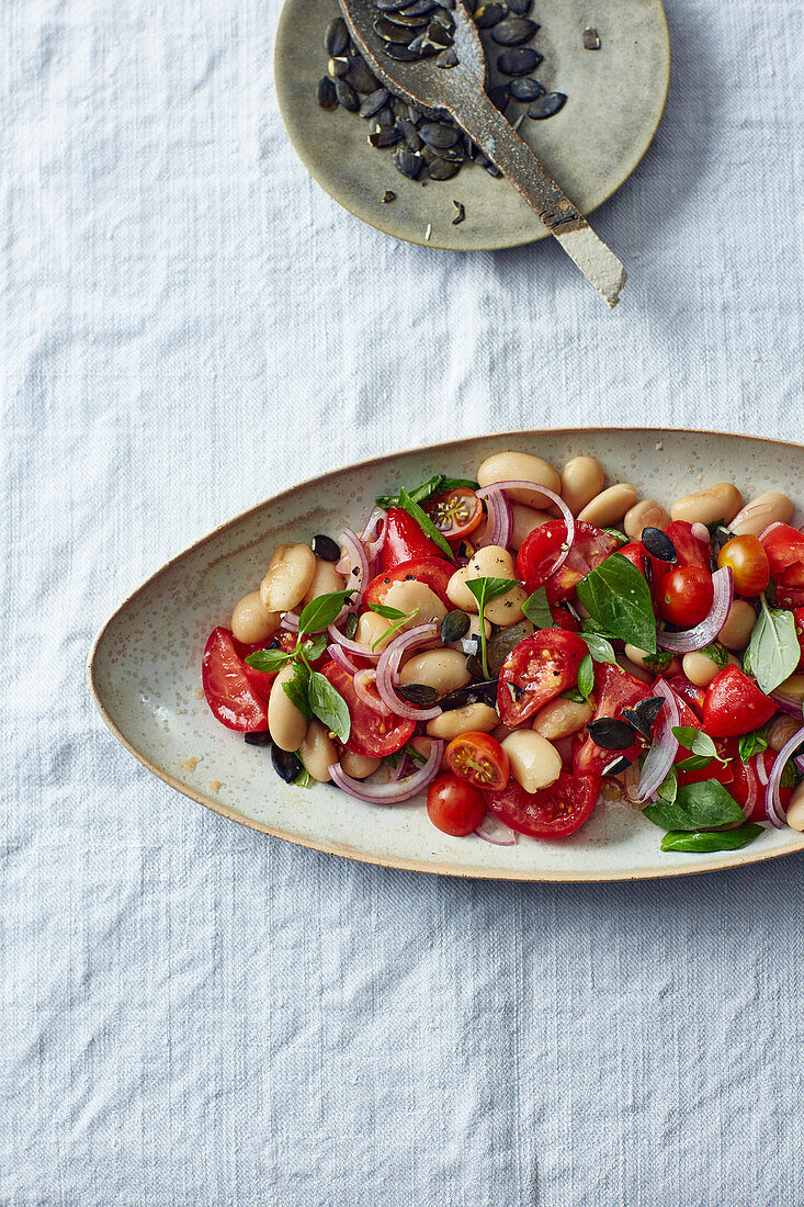 Vegan tomato salad with white beans and pumpkin seeds