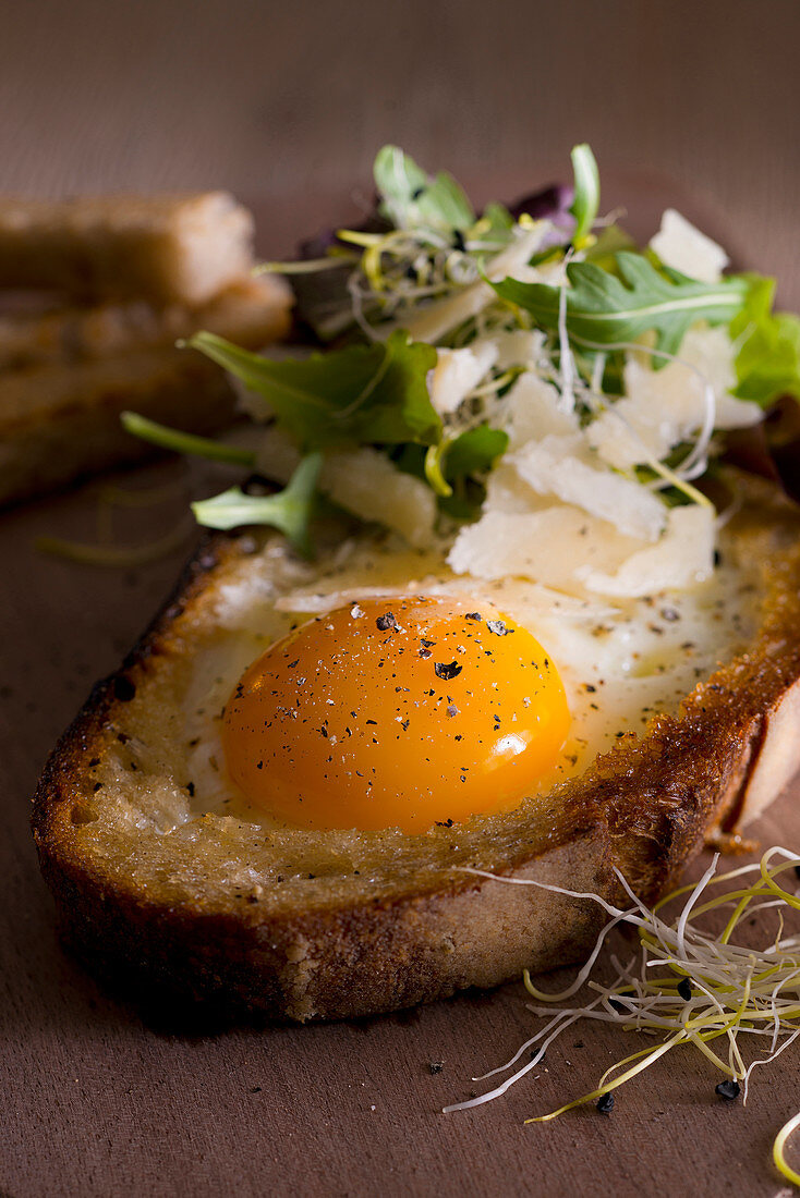 Ei im Röstbrot mit Pflücksalat, Sprossen und Parmesan