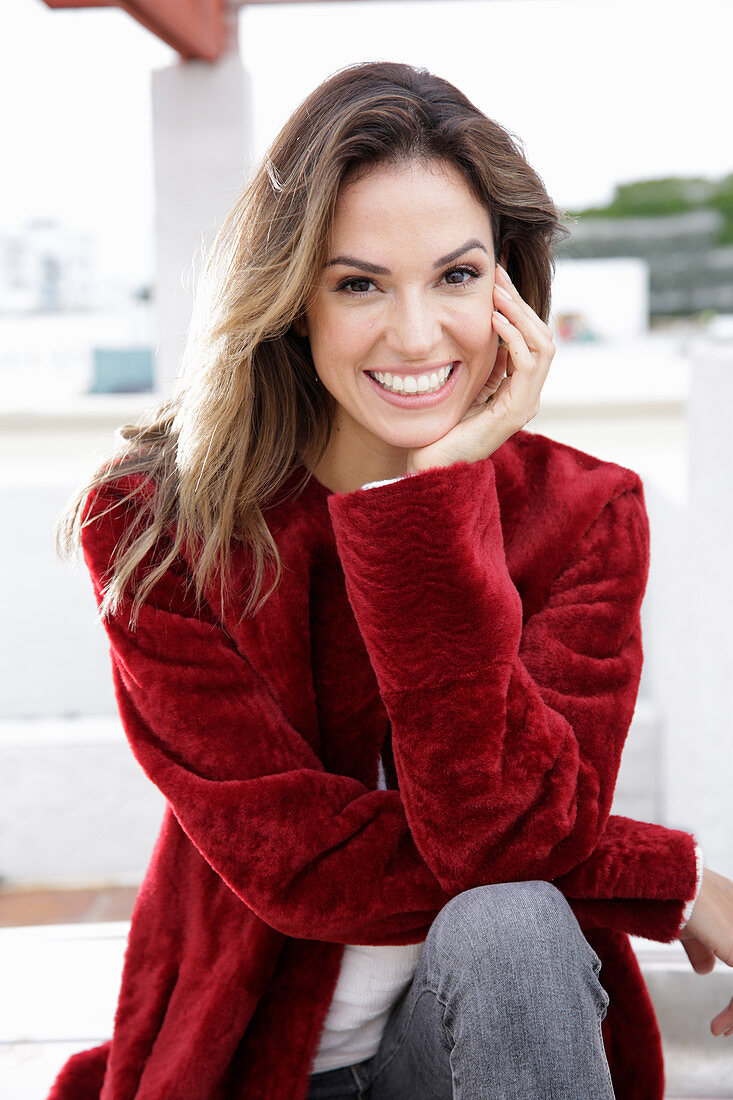 A young woman wearing a red coat