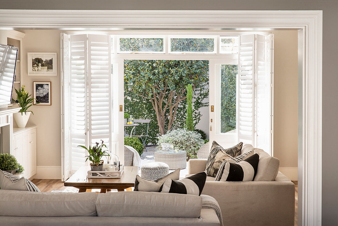 Wohnzimmer in Beige mit Blick auf die sonnige Terrasse