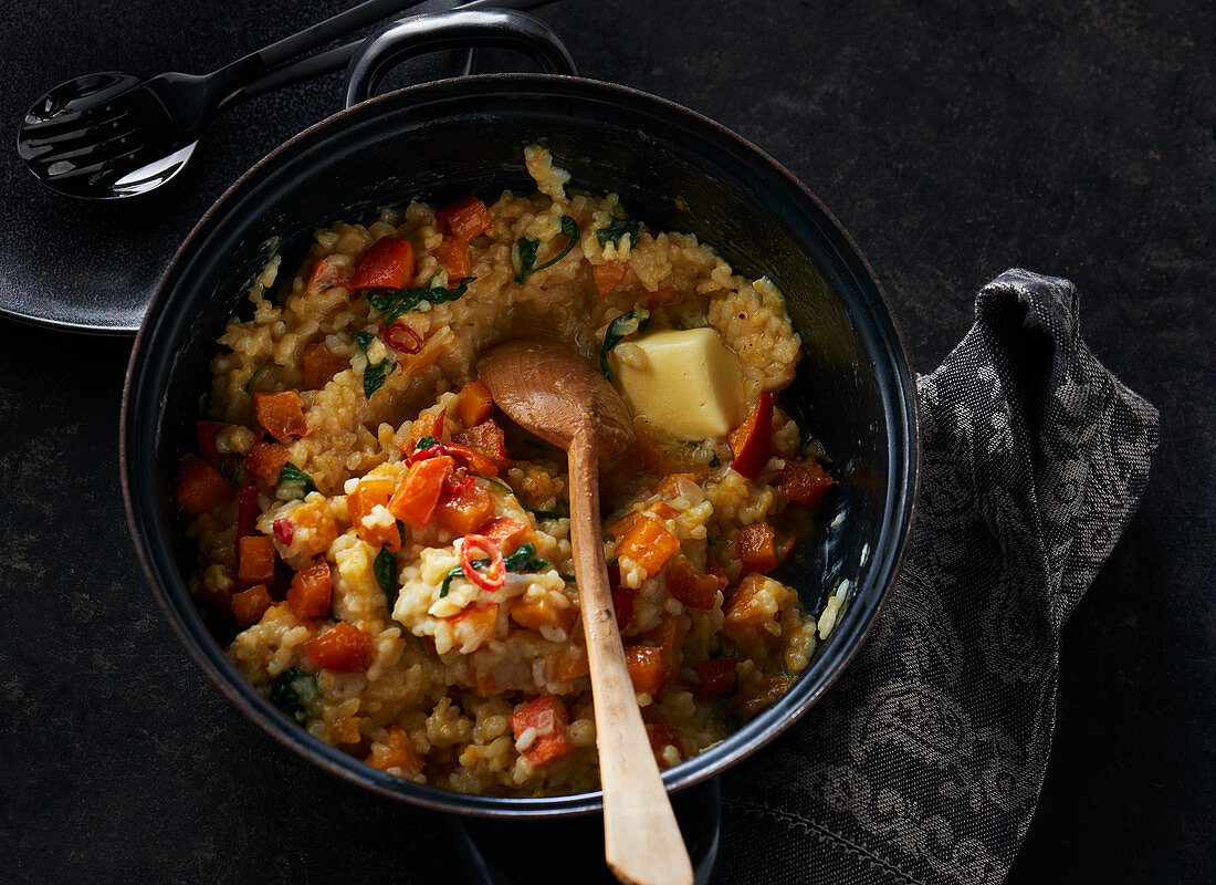 Süsskartoffel-Risotto mit Butterstück im Kochtopf