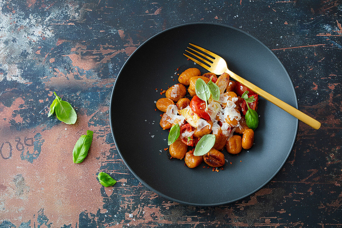 Gnocchi with pumpkin, spelled, tomatoes, garlic and parmesan