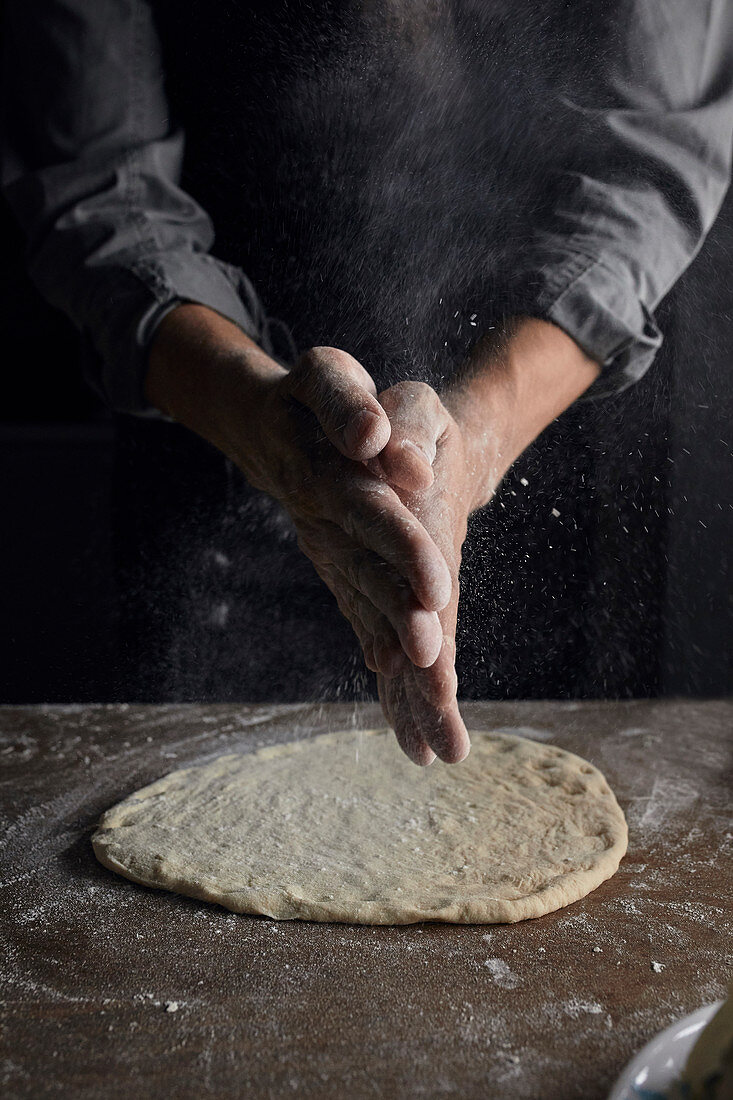 Sprinkling flour on flat sourdough
