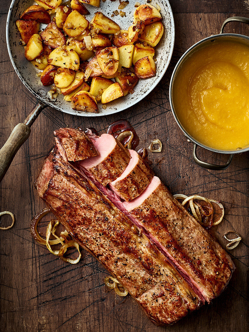 A whole saddle of wild boar with fried potatoes and apricot purée