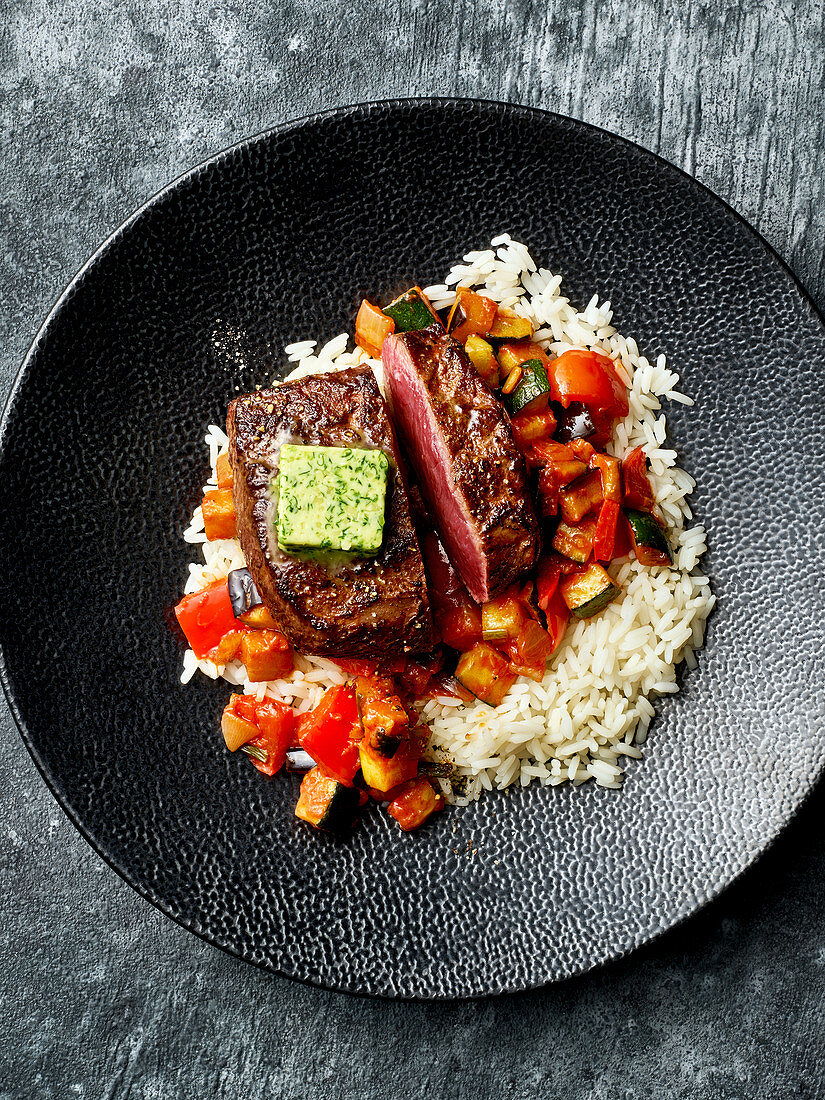 Fried vegetables with venison steaks and rice