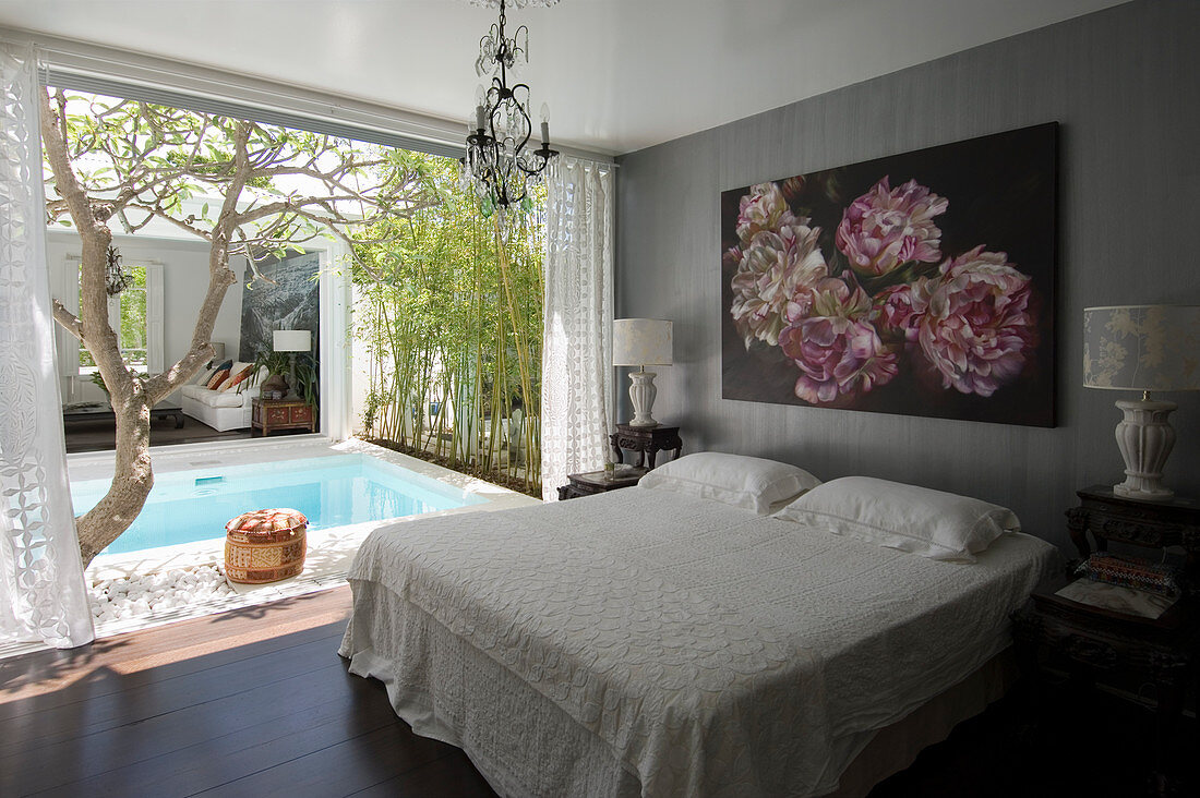 Floral artwork above double bed with view of pool